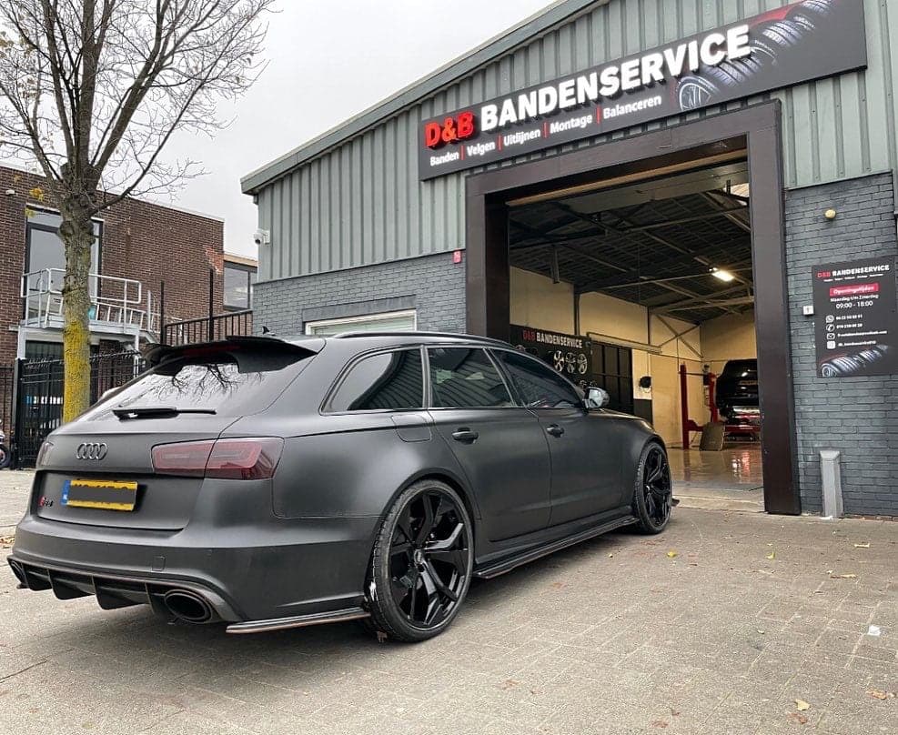 De gevel van D&B Bandenservice aan de Hontsloostraat met een open werkplaatsdeur en een auto ervoor